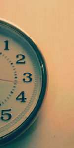 Close-up of clock on table against wall