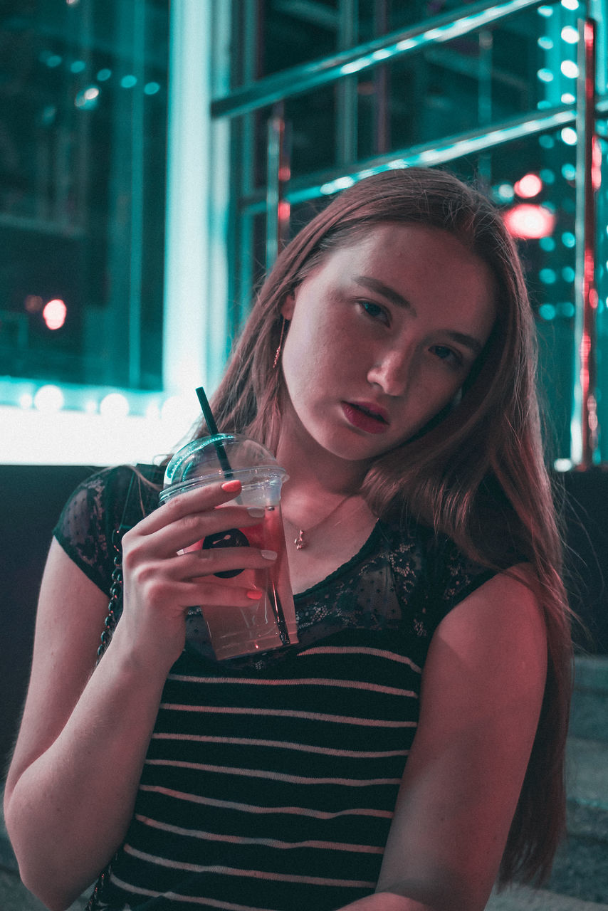 PORTRAIT OF A YOUNG WOMAN DRINKING WATER