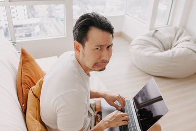 Frustrated man with laptop at home