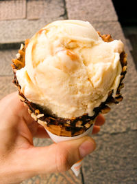 Close-up of cropped hand holding ice cream cone