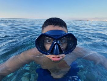Young man swimming in sea with mask