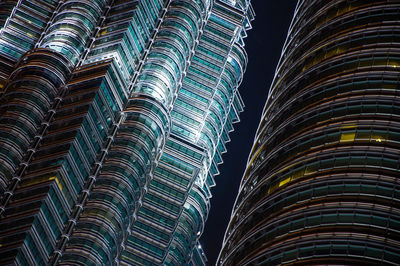 Low angle view of petronas towers skyscrapers against sky at night un kuala lumpur.
