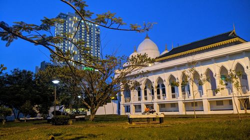 People outside temple against clear sky