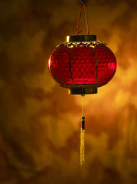 Close-up of illuminated lantern hanging against wall