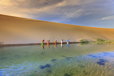 People enjoying in water against sky