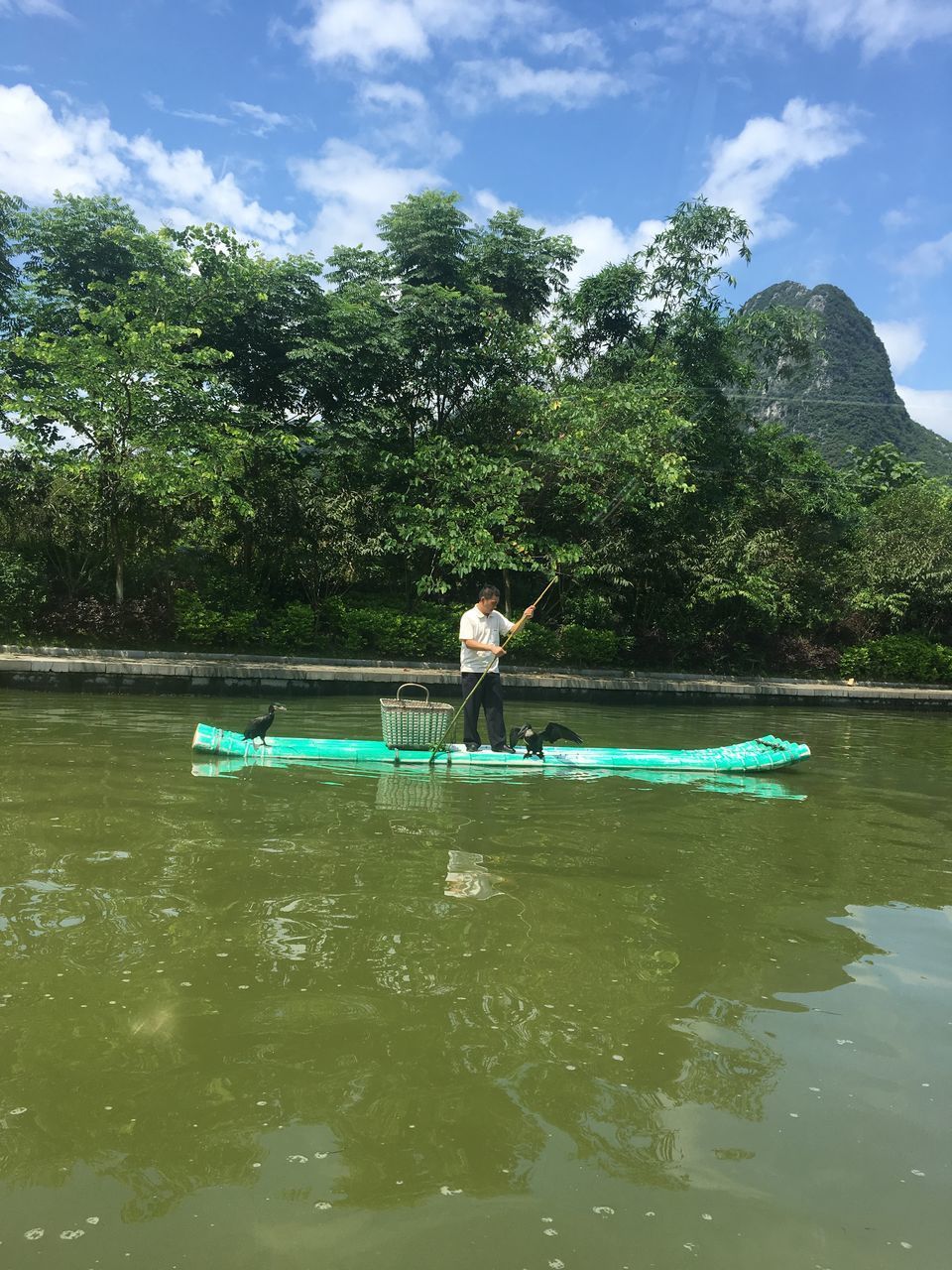 MAN ON LAKE AGAINST SKY