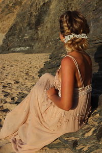 Rear view of woman sitting on beach