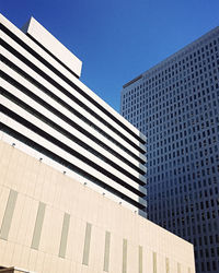 Low angle view of modern buildings against clear blue sky