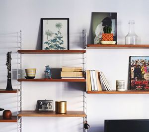Close-up of various objects on shelf against wall