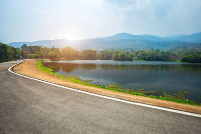 Road by lake against sky