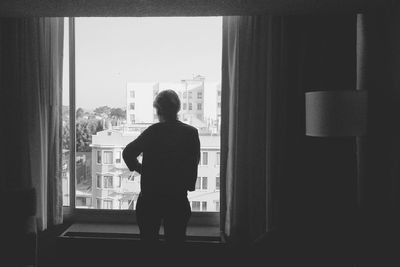 Man standing by window at home