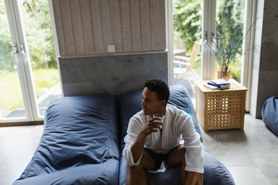 Man sitting on ben bag in living room