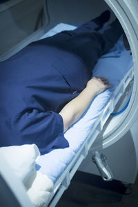 Midsection of patient lying down on bed at hospital