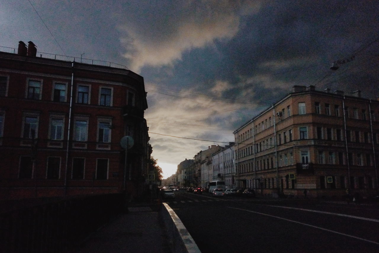 ROAD AMIDST BUILDINGS IN CITY AGAINST SKY