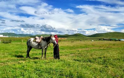 Woman with horse on grassland