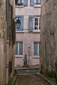 Woman walking on sidewalk in city