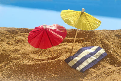 Close-up of red umbrella on beach