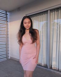 Portrait of beautiful young woman standing against wall