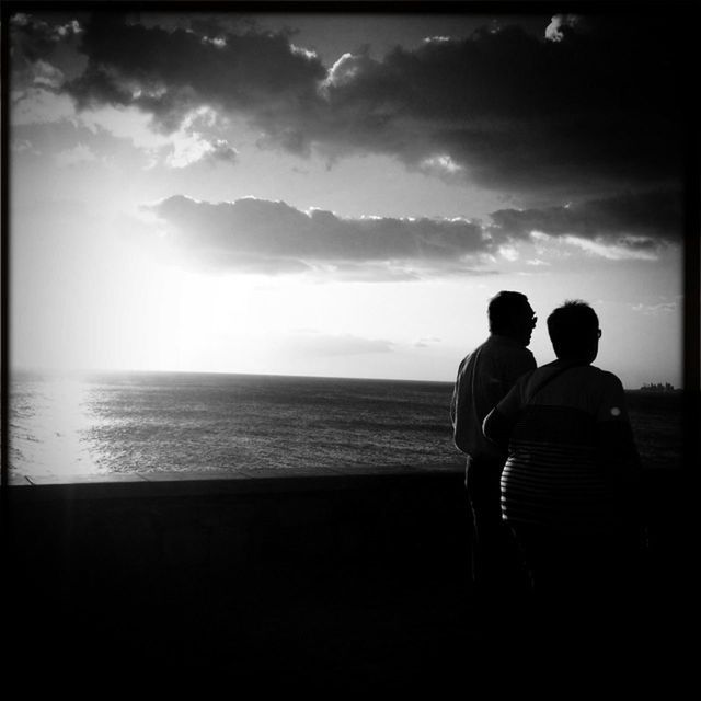 sea, togetherness, sky, horizon over water, silhouette, water, lifestyles, rear view, bonding, leisure activity, love, men, beauty in nature, tranquility, beach, scenics, tranquil scene, standing