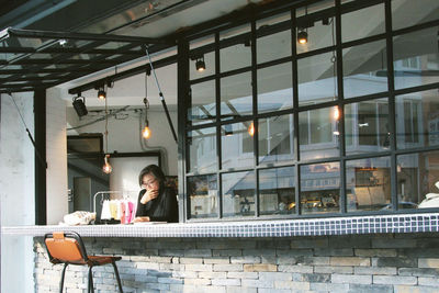 Woman sitting in cafe seen through window