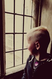 Portrait of boy looking through window
