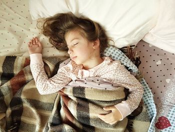 High angle view of girl sleeping on bed