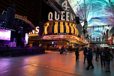 People on illuminated building at night