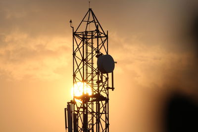 Low angle view of silhouette crane against sky during sunset