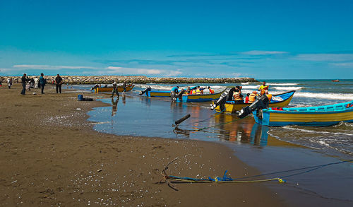 People on beach against blue sky