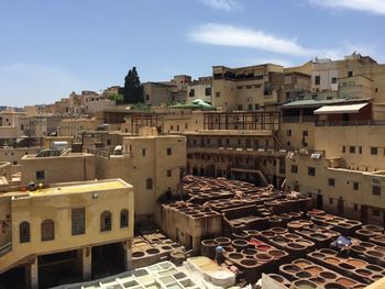 High angle view of old buildings in town against sky