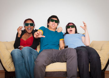 Happy friends sitting on sofa