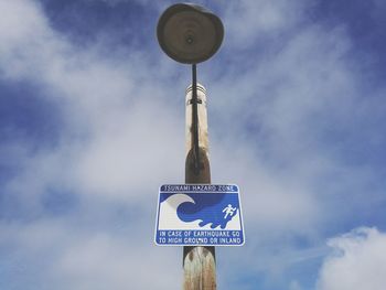 Low angle view of road sign against sky