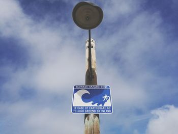 Low angle view of road sign against sky