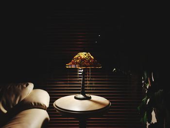 Close-up of illuminated lamp on table