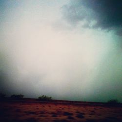 Scenic view of field against cloudy sky