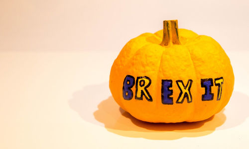 Close-up of pumpkin on table against white background