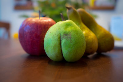 Close-up of apples and a pear on table