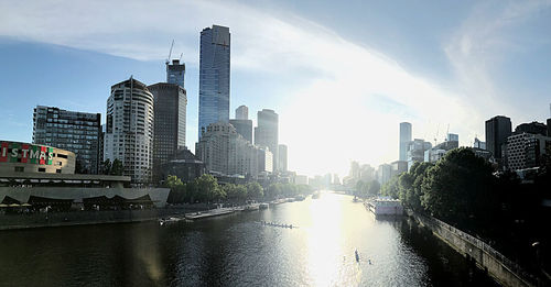 River amidst buildings in city against sky