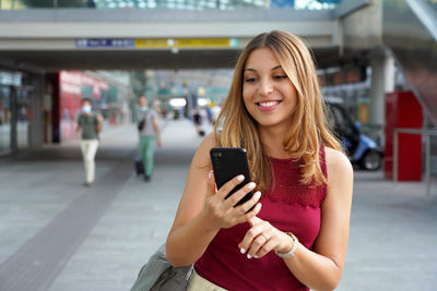 Smiling young woman using mobile phone