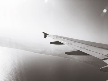 Airplane flying over landscape against sky