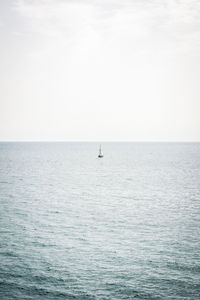 Sailboat sailing in sea against clear sky