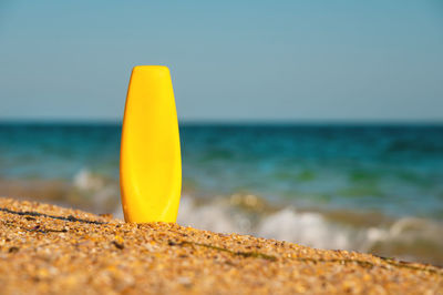 Bright cream product packaging on the sea coast. empty bottle for advertising care cosmetics