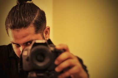 Close-up of man photographing through camera