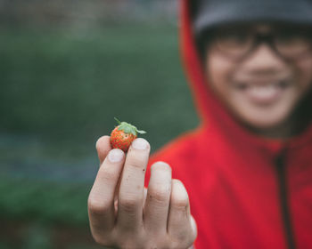 Portrait of smiling boy showing strawberry