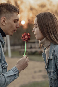 Young man and woman blowing on a wind toy, ecology concept