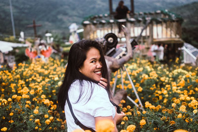 Portrait of a happy woman with flowers on plants. 