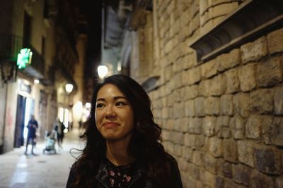 Portrait of woman standing against brick wall