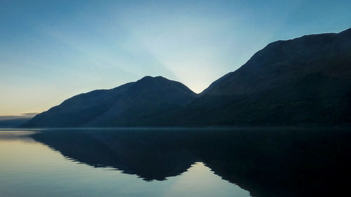 Calm lake with mountains in background