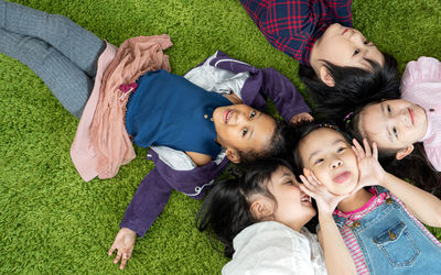 High angle view of friends lying on grass