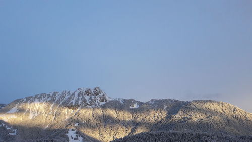 Scenic view of snowcapped mountains against clear blue sky